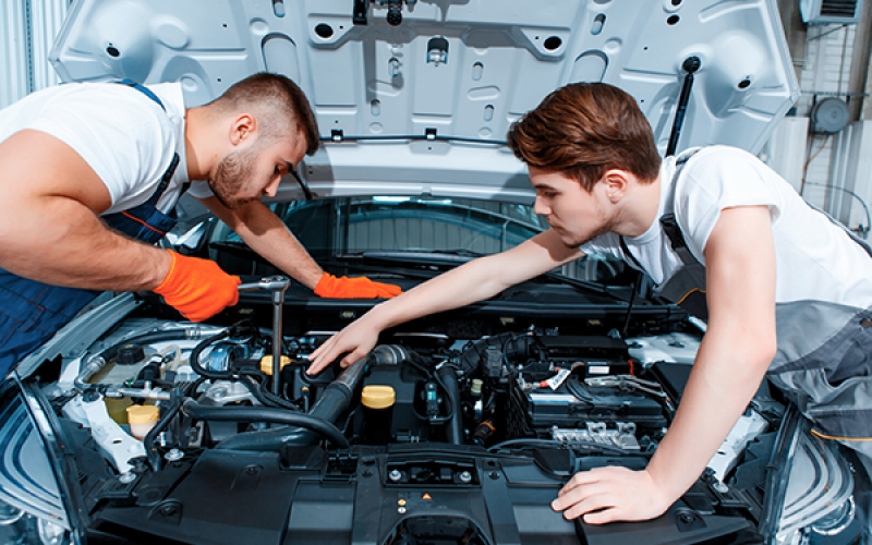 two mechanics working on engine