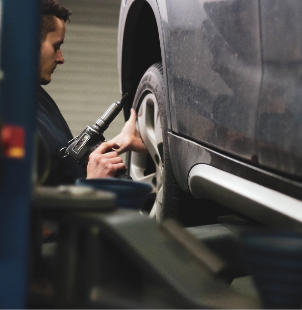benjamin-brunner-_kvdYDxvnCo-unsplash Mechanic working on a car wheel